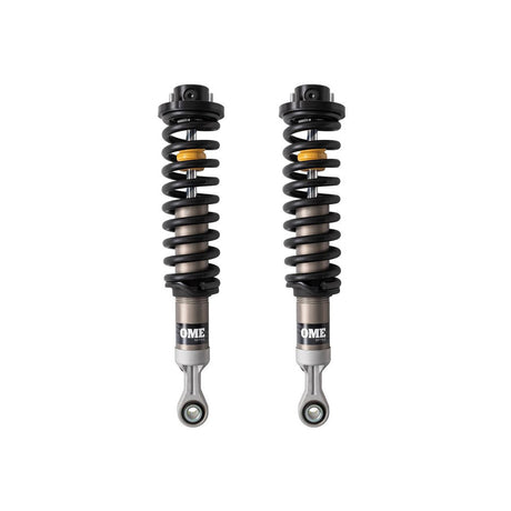 Black and sliver OME coilovers on a white background