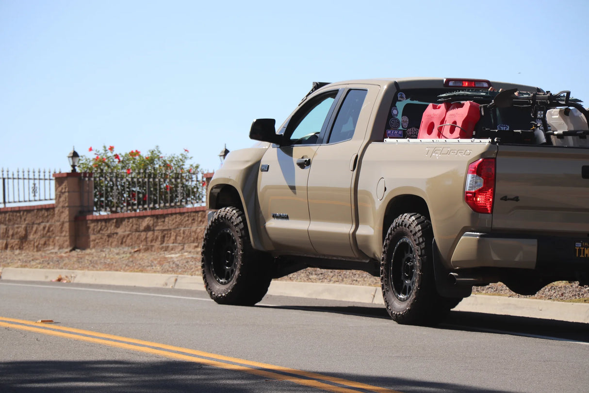 Beige pickup truck on a road with a clear blue sky