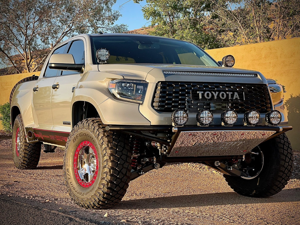 Toyota truck on a dirt road with trees in the background