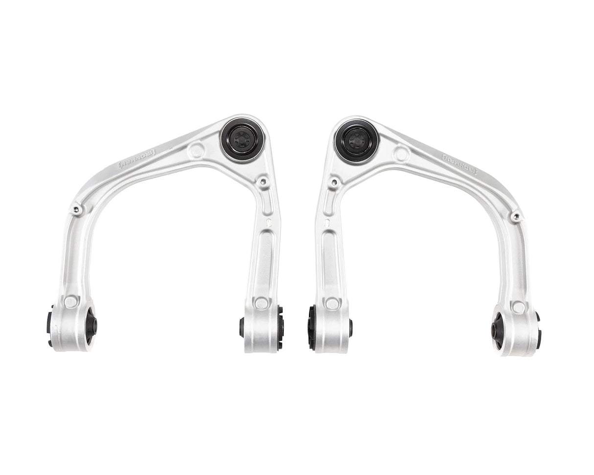 Two metal suspension control arms on a white background