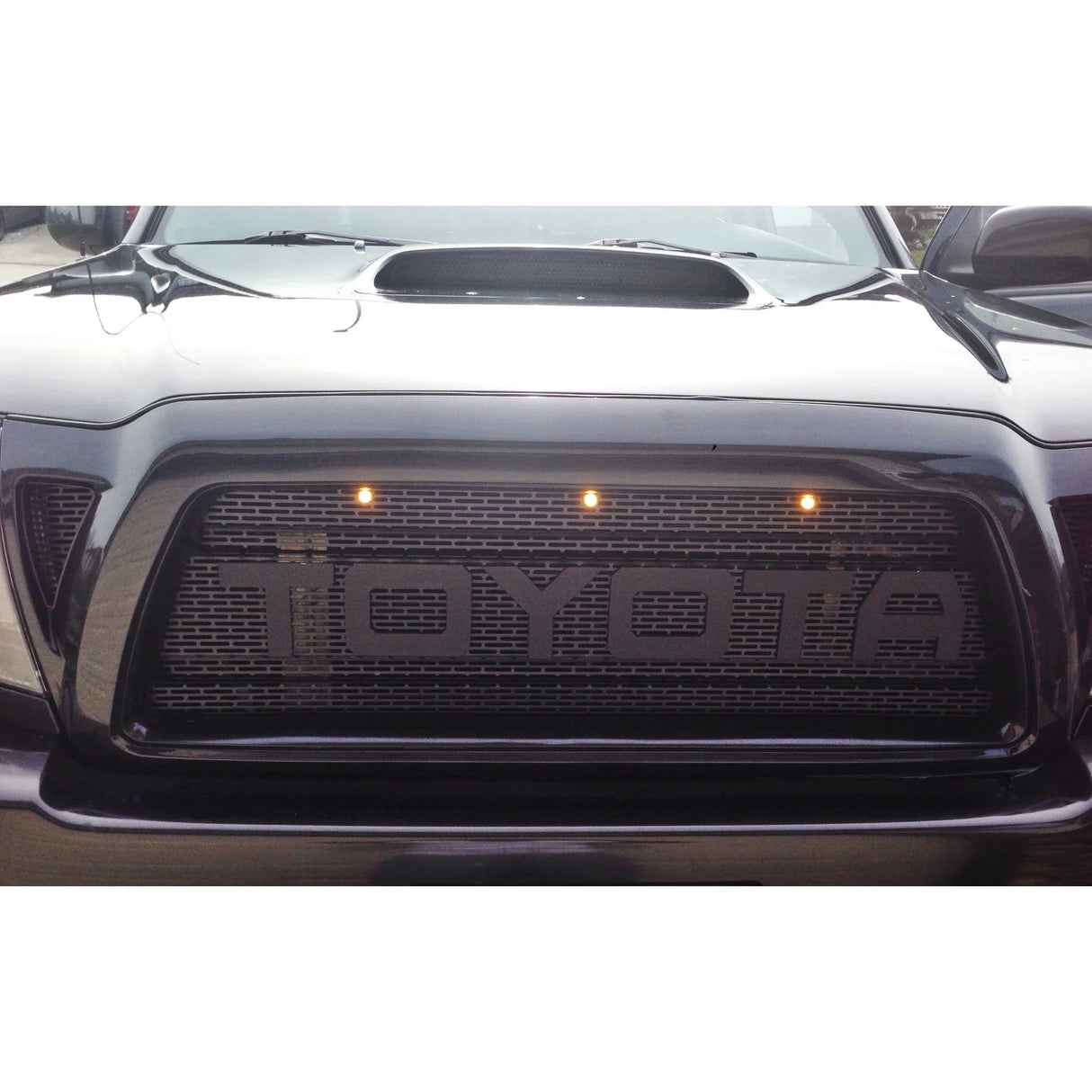 Front view of a Toyota car with illuminated logo