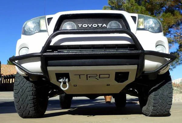 Front view of a white Toyota truck with 'TRD' badge on a clear day.