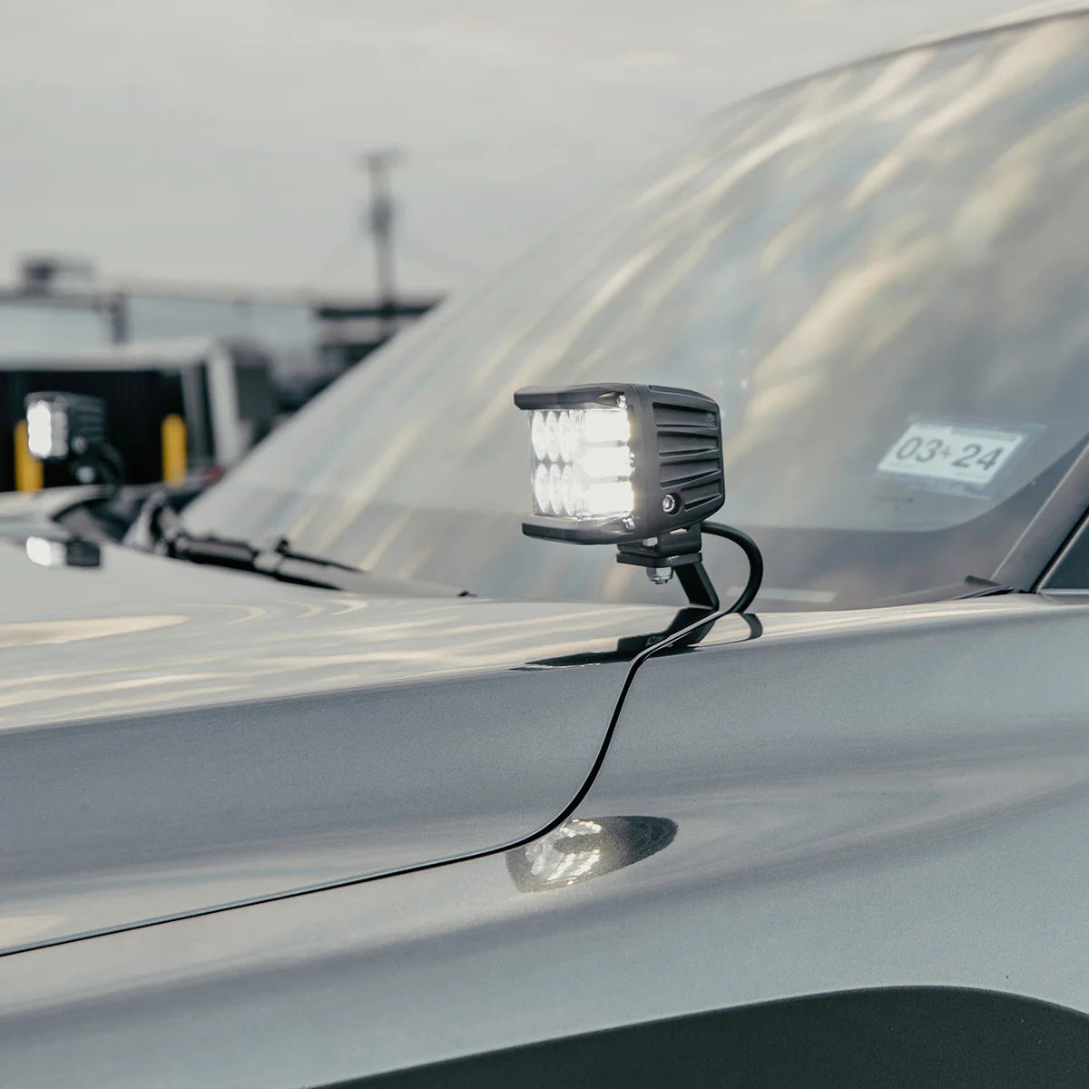 Car light mounted on a vehicle's hood with a blurred background