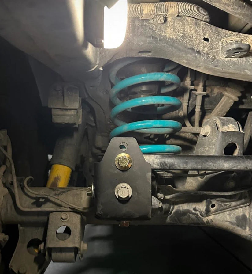 Close-up of a vehicle's suspension system with a blue spring.