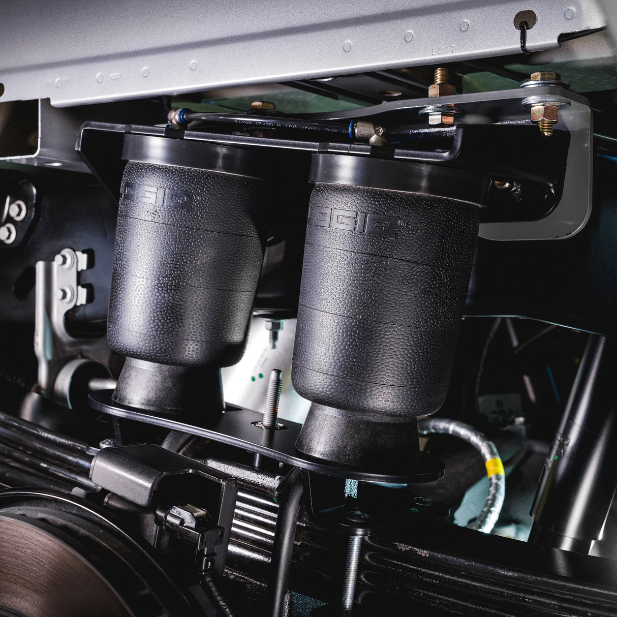 Close-up of a vehicle's suspension system with two black shock absorbers.