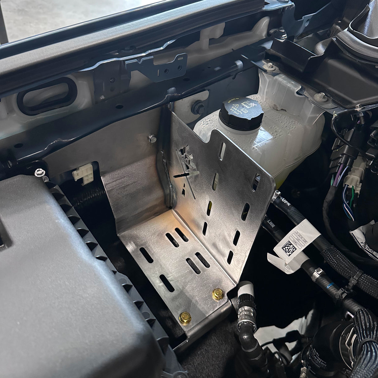 Close-up of a car's engine compartment with various components.