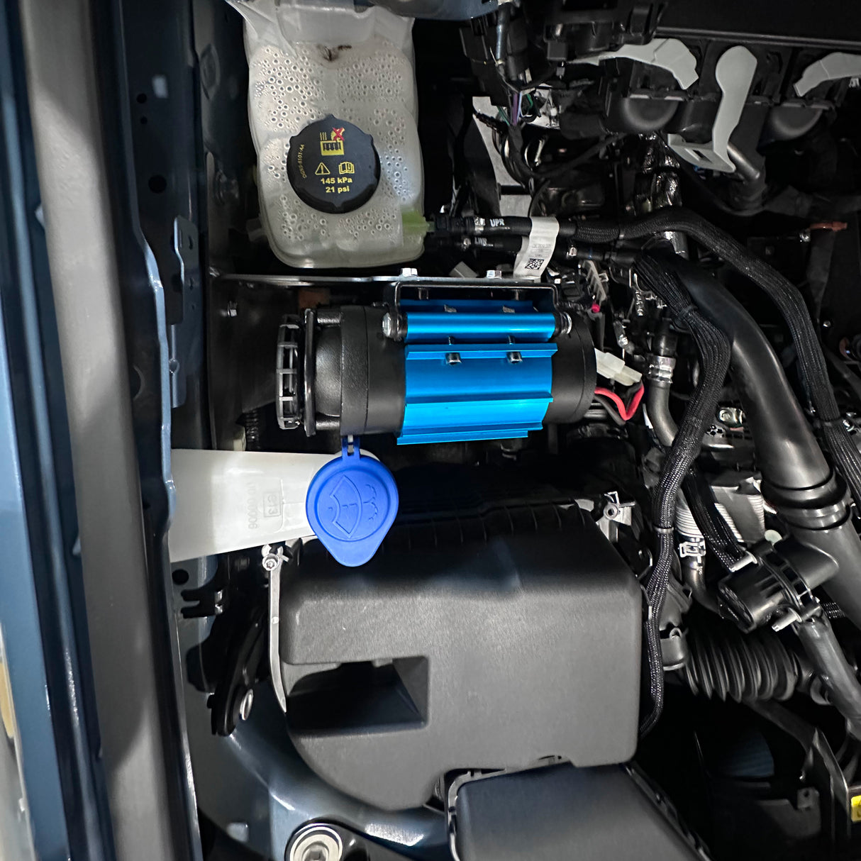 Close-up of a car engine with a blue component