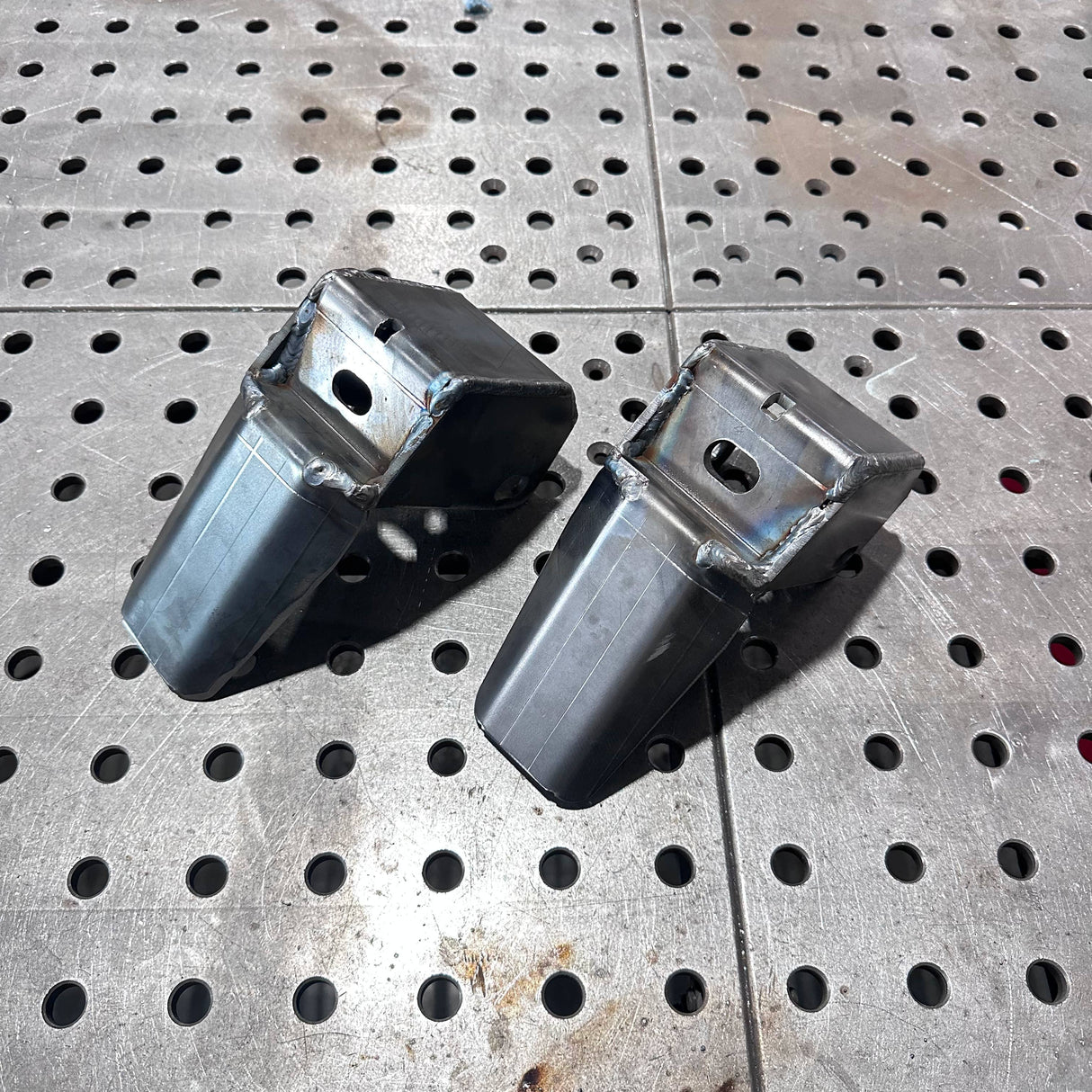 Two metal components on a perforated metal surface