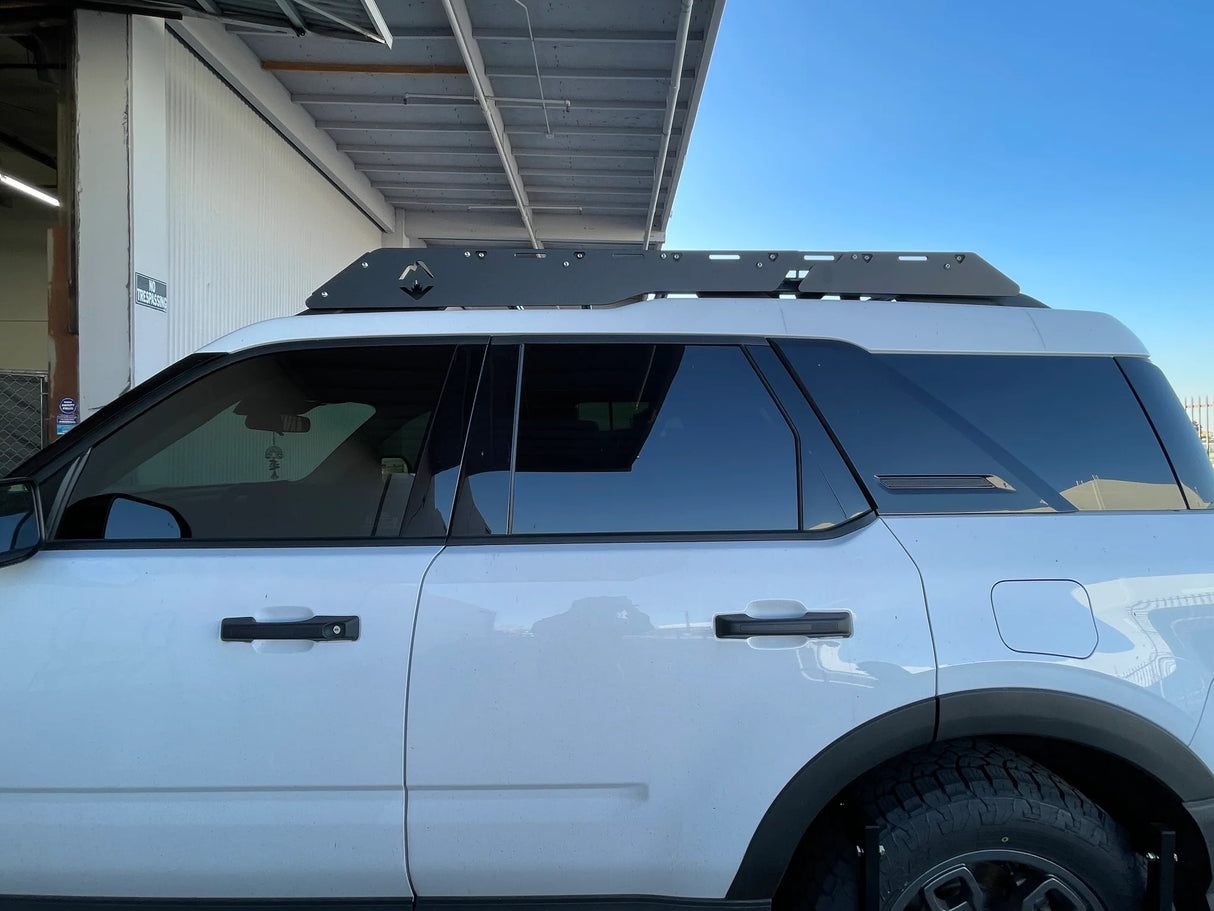 White SUV with a roof rack on a clear day