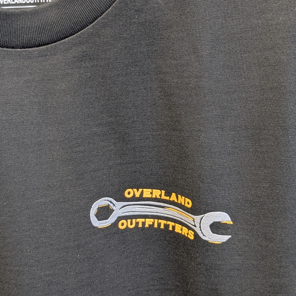 Close up of front graphic small wrench with Overland Outfitters surrounding it