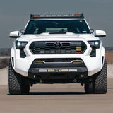 White 2025 Tacoma with stealth bumper on a road
