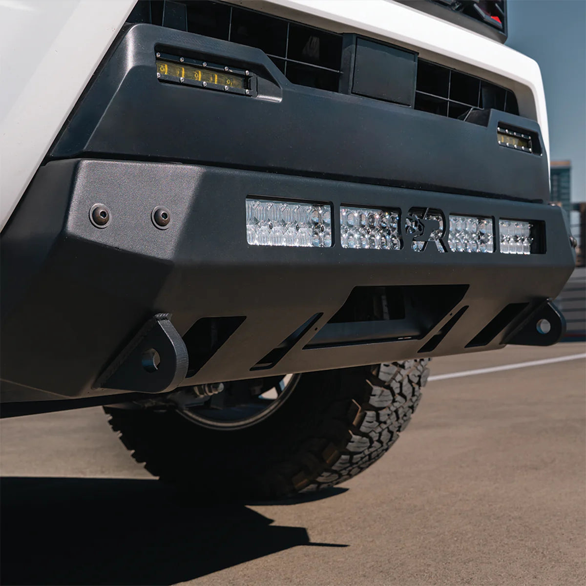 White Tacoma on pavement with stealth bumper
