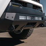 White Tacoma on pavement with stealth bumper

