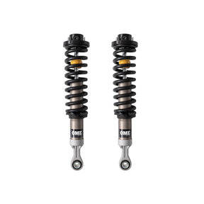 Black and sliver OME coilovers on a white background