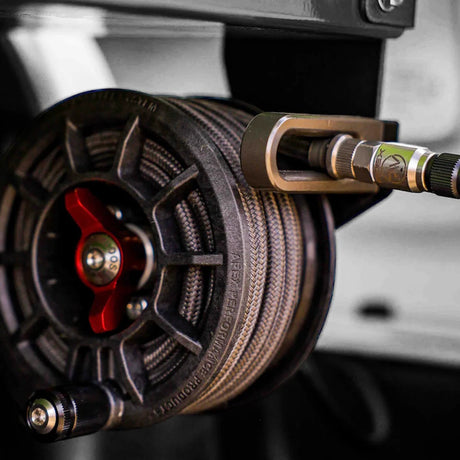 Close-up of a tire pressure gauge attached to a vehicle tire.