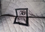 Close-up of quilted fabric with a square cutout and rolled-up object inside.