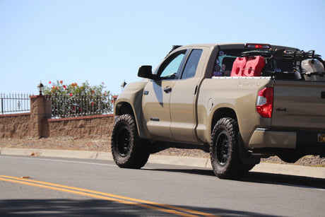 Beige pickup truck on a road with a clear blue sky