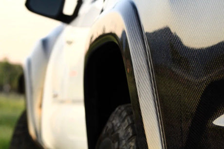 Close-up of a car's side mirror and fender with a blurred background