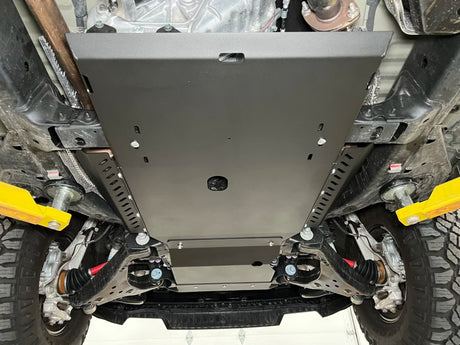 Close-up of a vehicle's undercarriage with a metal guard installed.