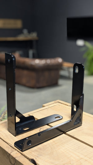 black metal channel stiffener on wooden surface with blurred backrground