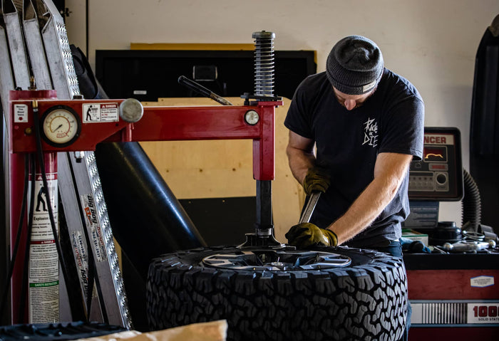Person working on a tire in a garage setting