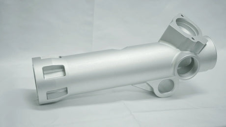 Metallic cylindrical component on a gray background