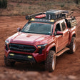 Red Toyota truck with off-road equipment on a dirt road