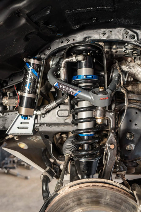 Underside of truck featuring suspension system parts with PEAK branding