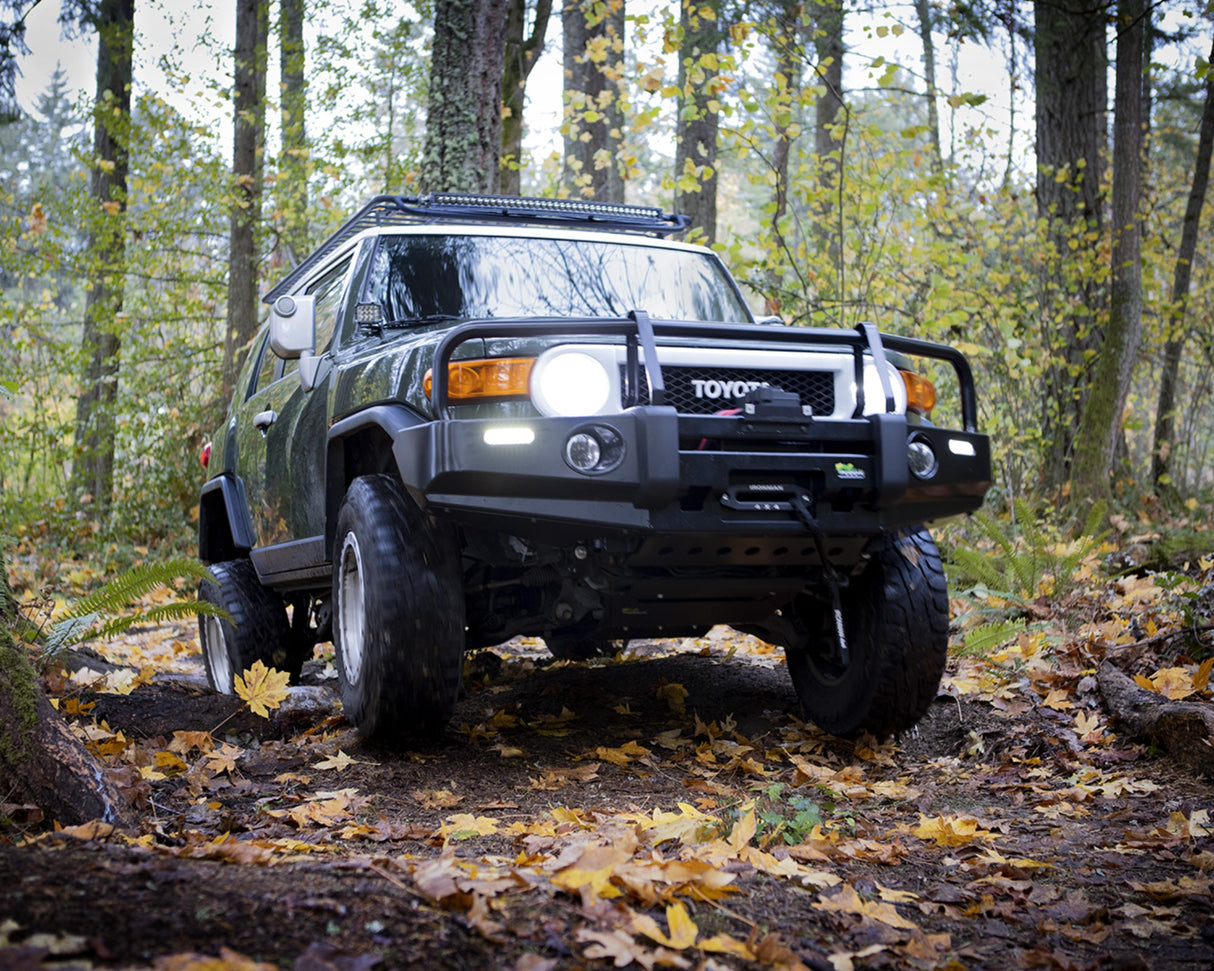 Toyota FJ Cruiser on a forest trail with autumn leaves