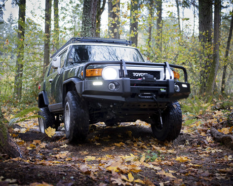 Toyota FJ Cruiser on a forest trail with autumn leaves