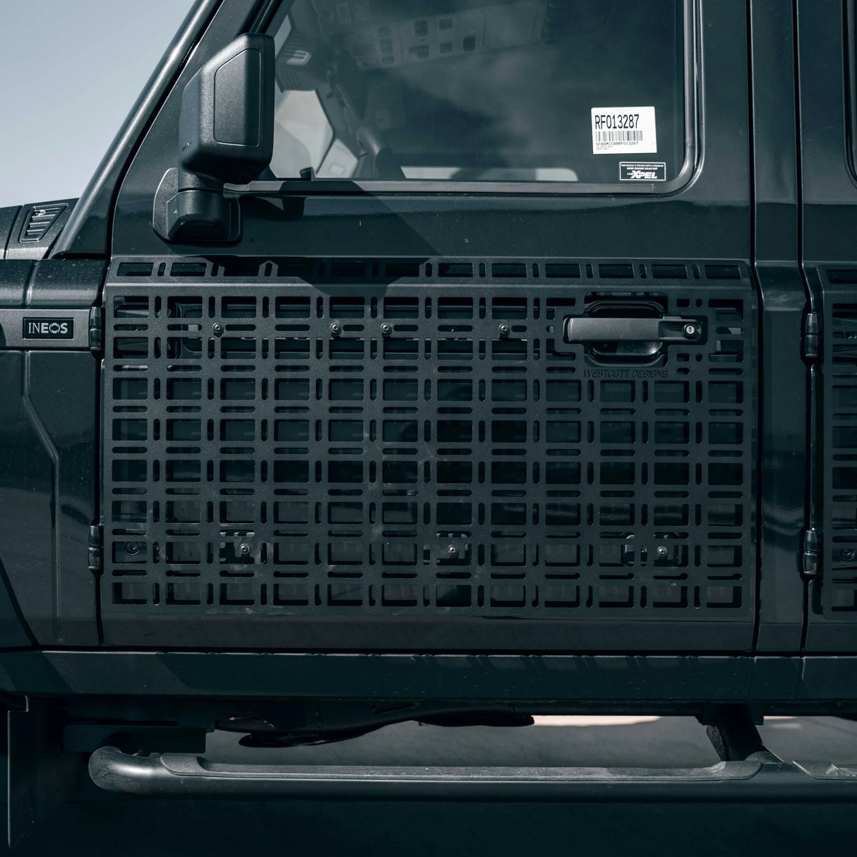 Close-up of a black vehicle grille with INEOS branding