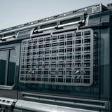 Metal cargo basket attached to a vehicle's roof rack with a clear blue sky background