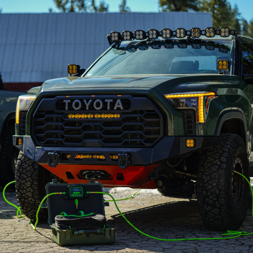 Toyota truck with off-road equipment and an air compressor on a paved surface.