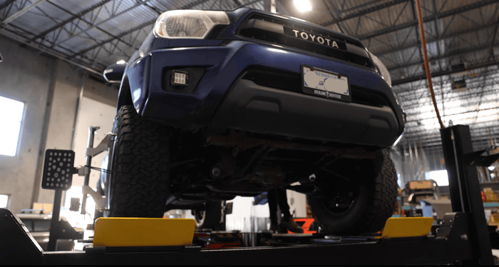 Blue Toyota vehicle on a lift in a garage setting
