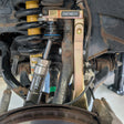 Close-up of a vehicle suspension system with 'APEX' and 'XMOTO' branding.
