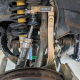 Close-up of a vehicle suspension system with 'APEX' and 'XMOTO' branding.