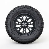 Black off-road tire with a detailed tread pattern on a white background