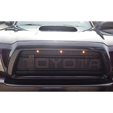 Front view of a Toyota car with illuminated logo