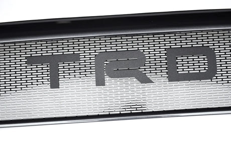 Metallic grille with 'TRD' logo on a white background