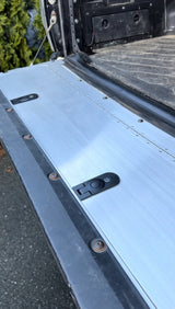 Close-up of a metal surface with a latch on a vehicle bed.