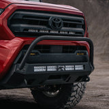 Red Tacoma with stealth bumper and bull bar on dirt road