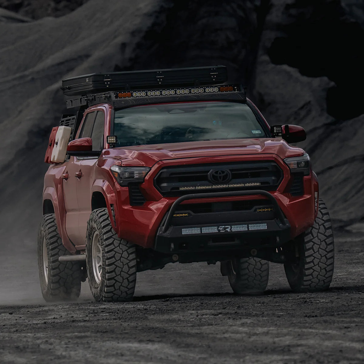 Red Tacoma driving on dirt road with Stealth Bumper

