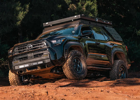 Toyota truck on a dirt road with trees in the background