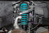 Close-up of a car suspension system with green shock absorbers.