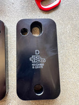 Black metal plate with branding on a gray surface