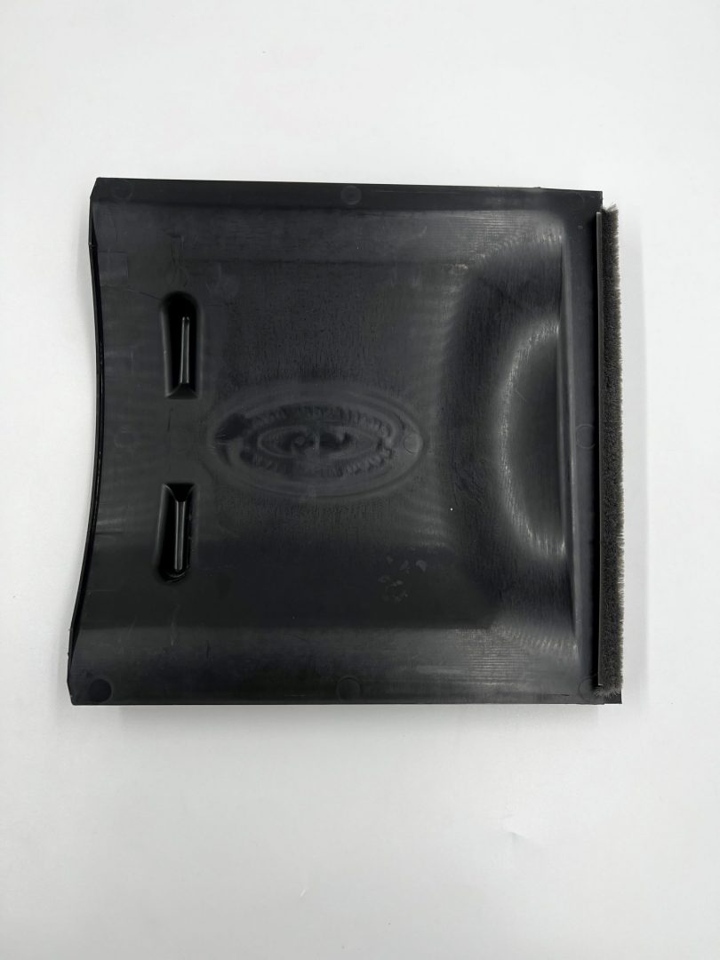 Black plastic component with branding on a white background