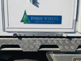 Four Wheel Pop-up Campers logo on a vehicle, with a step bracket under the door.