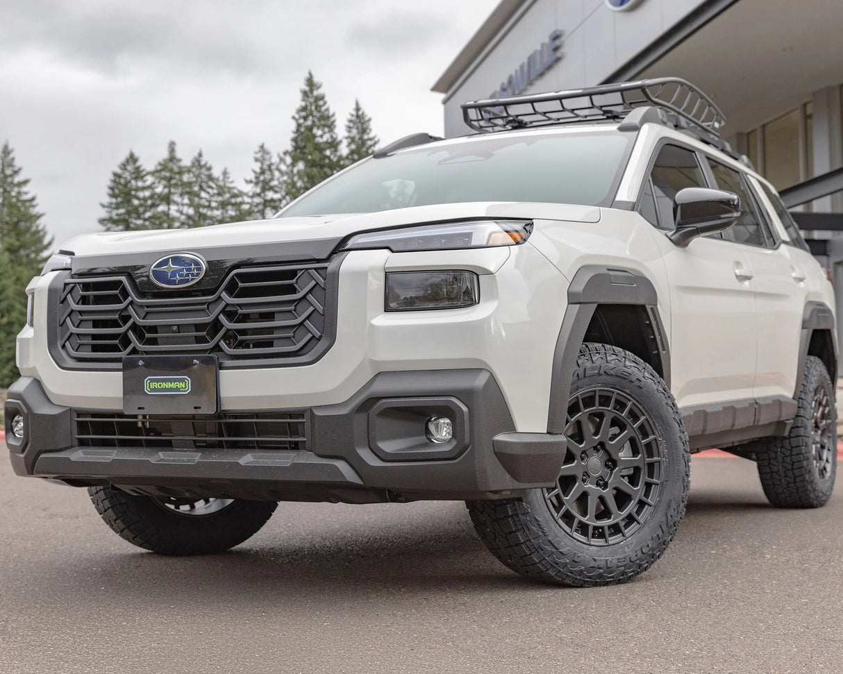 White SUV with off-road modifications parked on a paved surface.