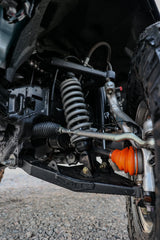 Close-up of a vehicle's suspension system with an orange shock absorber.