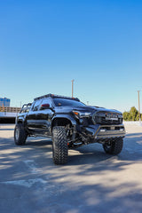 Black Toyota truck on a concrete surface with a clear blue sky in the background